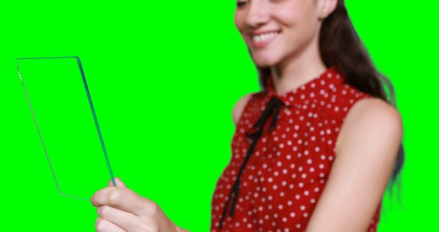 Woman pretending to use digital tablet against green screen