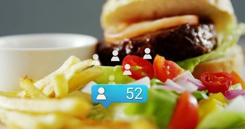 Closeup burger with fries and fresh salad featuring notification bubble 52 for media marketing