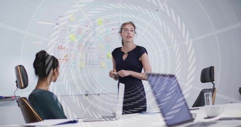 Woman presenting project plan at whiteboard during collaborative team meeting in office