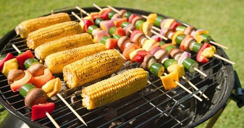 Grilled Corn and Vegetable Skewers on Charcoal BBQ in Sunny Backyard