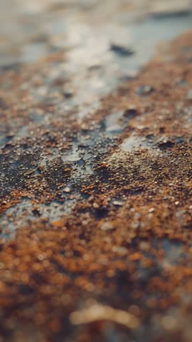 Vertical rack focus macro revealing rusted metal texture with droplets and cinematic bokeh