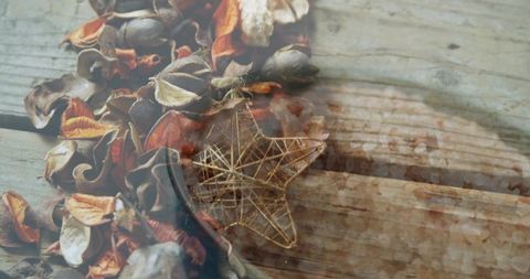 Rustic potpourri with wire star ornament on weathered wood plank evoking cozy autumn warmth