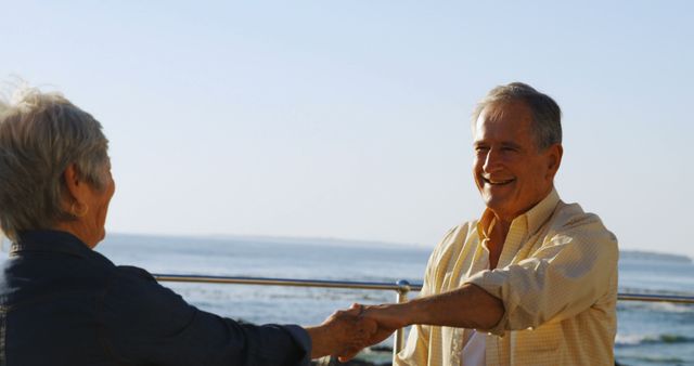 Happy senior caucasian couple holding hands by sea. Retirement, relationship, love, togetherness, free time and relaxing, unaltered.