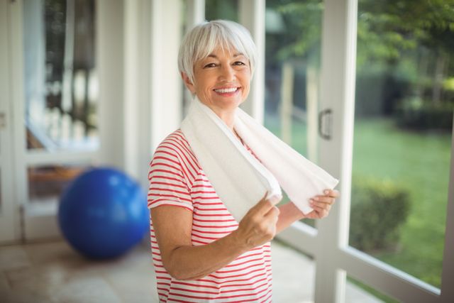 Portrait of smiling senior woman with towel at home