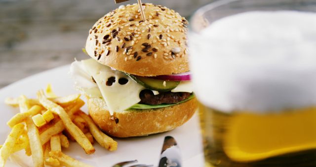 A cheeseburger with sesame seeds, served with fries and a glass of beer, presents a classic American meal. The combination suggests a casual dining experience, often associated with comfort food and social gatherings.