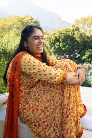 Joyful indian woman relaxing outdoors in bright traditional attire