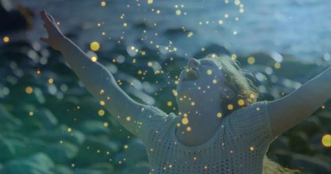 Joyful woman embracing magic at ocean shore