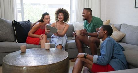 Diverse Friends Relaxing in Living Room with Digital Tablet and Coffee