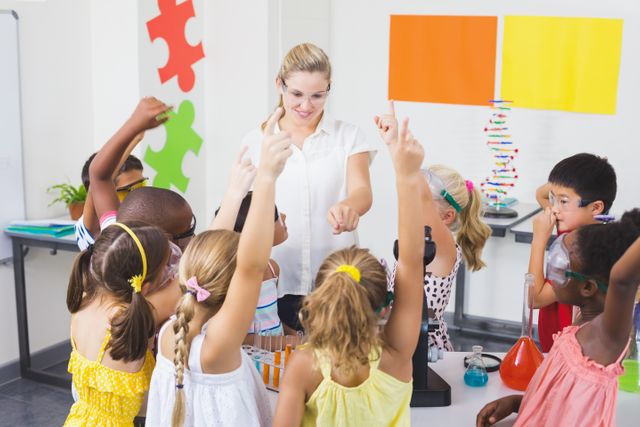 Children eagerly raising their hands in a science class, indicating active participation and interest. The teacher is engaging with the students, fostering a positive learning environment. Ideal for educational content, school promotions, STEM programs, and articles on child development and interactive learning.