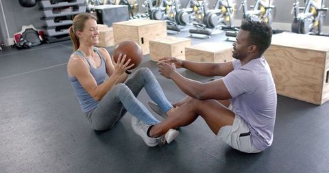 Diverse Duo Motivational Exercise with Medicine Ball in Gym