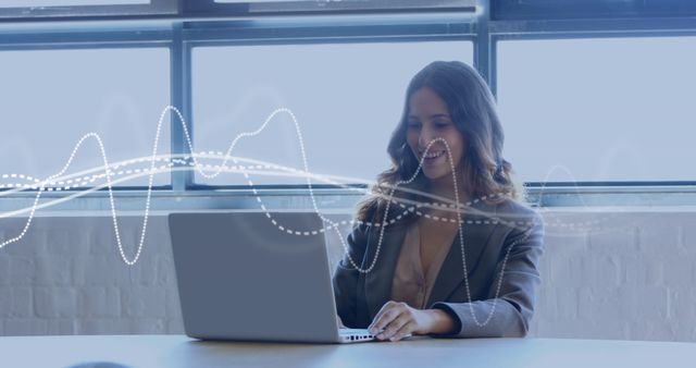 Businesswoman working on laptop with emerging digital interface in modern office setting. Ideal for illustrating technology innovation, remote work environment, professional development, digital marketing, or connectivity.