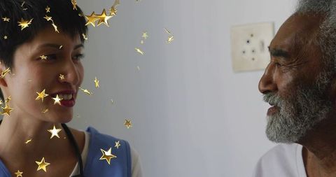 Compassionate caregiver smiling and engaging senior patient in clinic, golden star overlay