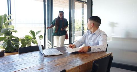 Multiracial colleagues in informal office meeting