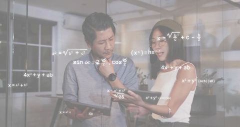 Colleagues analyzing data on tablets with math formulas overlay in modern glass office
