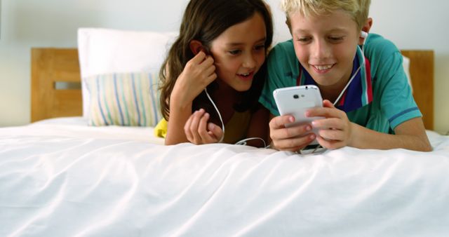 Two kids bond over shared earbuds and smartphone content, highlighting digital camaraderie. - Download Free Stock Photos Pikwizard.com