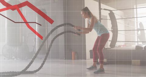 Woman using battle ropes with declining graph