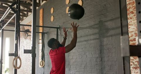 Man Throwing Medicine Ball in Industrial Gym