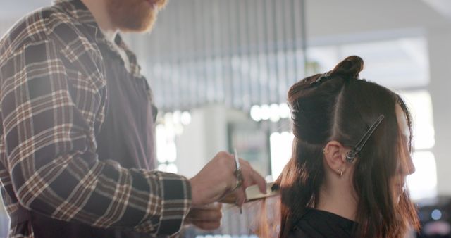 Caucasian male hairdresser giving haircut to caucasian female client at hair salon. Hair salon, beauty, work and small business, unaltered.