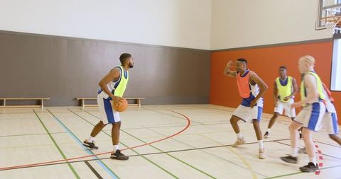 Diverse basketball players competing on indoor court