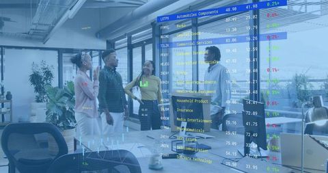 Business team reviewing live stock market data on glass wall in modern collaborative office