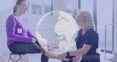 Therapist adjusting prosthetic leg with digital globe overlay