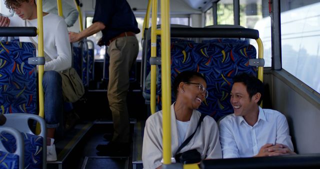 Happy diverse couple sitting in city bus talking, copy space. Transport, city living and lifestyle, unaltered.