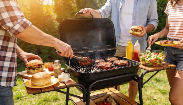 Backyard summer barbecue with friends grilling burgers and serving fresh salad outdoors