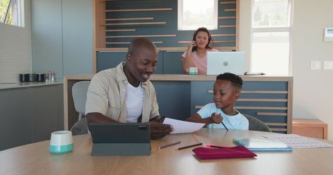 Father and Son Learning Together at Modern Kitchen Table