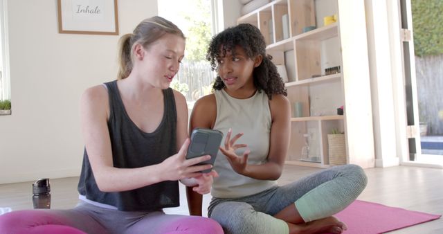 Two Women Using Phone While Relaxing on Yoga Mats - Download Free Stock Images Pikwizard.com