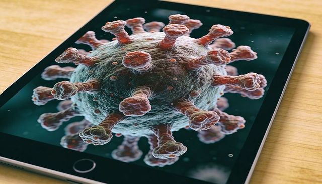 Tablet displaying coronavirus 3d render on light wood desk, close-up virus visualization
