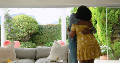 Couple Relaxing and Hugging on Patio with Scenic Garden View