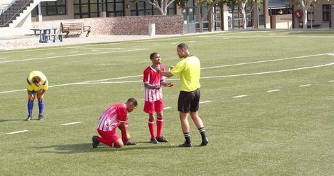 Soccer Players Discuss with Referee During Match Action