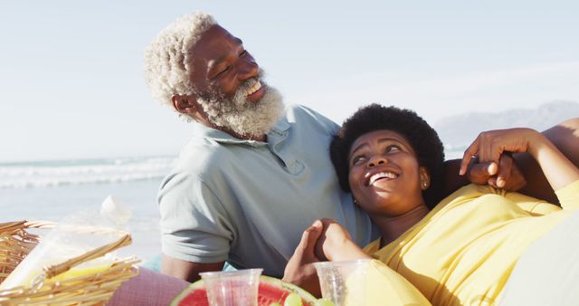 Happy african american couple having picnic on sunny beach - Download Free Stock Photos Pikwizard.com