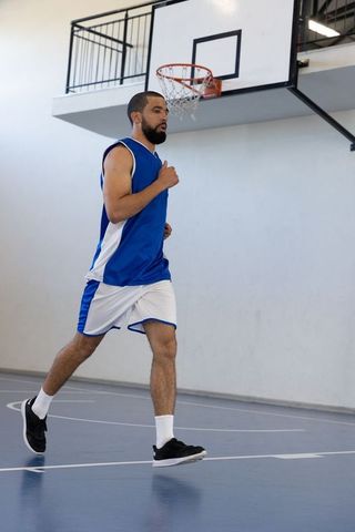 Basketball player running across indoor gym court