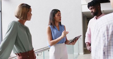 Diverse business team discussing project in modern office lobby