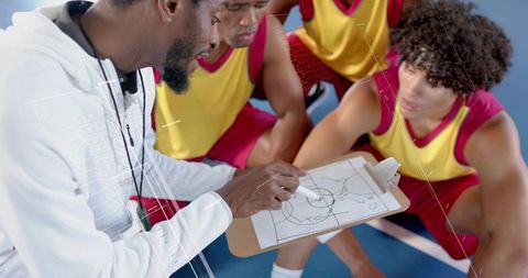 Basketball coach discussing strategy with team during practice