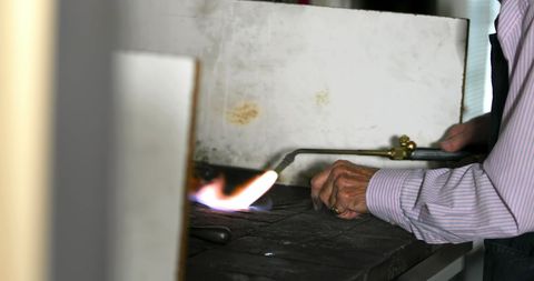 Goldsmith Crafting Intricate Design in Workshop