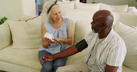 Senior Couple Monitoring Blood Pressure at Home Fostering Health and Wellness