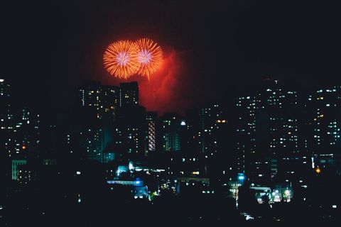 Vibrant Fireworks Over Bustling Cityscape at Night