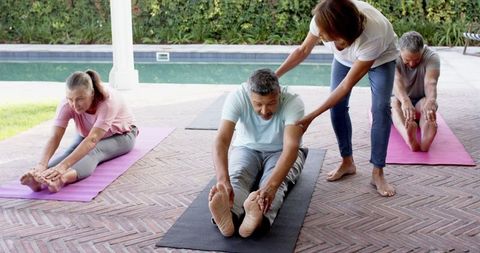 Group Practicing Yoga Led by Instructor in Outdoor Setting