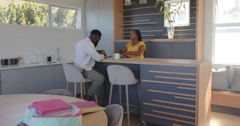 Couple Chatting at Modern Kitchen Counter with Coffee
