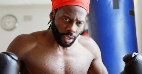 Determined Male Boxer Training with Punching Bag