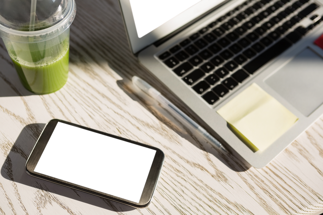 Transparent Smartphone with Laptop and Green Juice on Wooden Table - Download Free Stock Videos Pikwizard.com