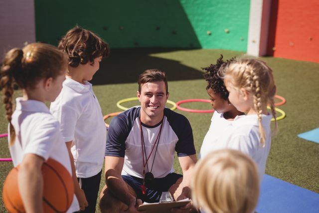 Happy coach with schoolkids in schoolyard