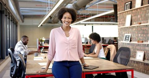 Confident Businesswoman Standing with Tablet in Modern Office Space