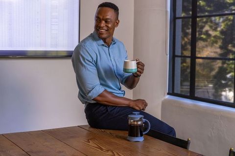 Professional man relaxing with coffee in modern office