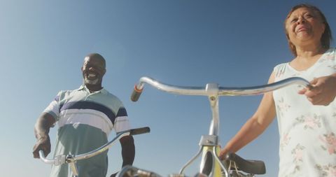 Senior Couple Enjoying Leisurely Beach Walk with Bicycles - Download Free Stock Images Pikwizard.com