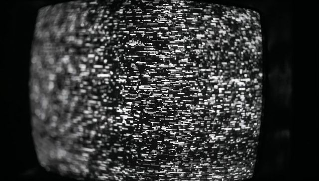 Black and White TV Static on Curved Screen in Dim Room