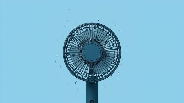 Electric Fan Front Grill on Minimalist Blue Background with Water Droplets