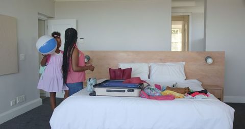 Mother and daughter packing suitcase for vacation adventure